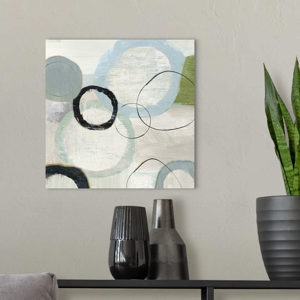 A modern room featuring An abstract painting of circles in varies sizes and colors.