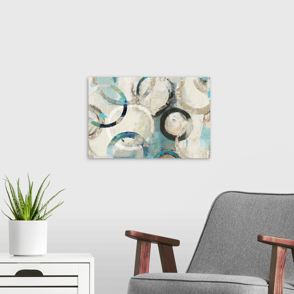 A modern room featuring Abstract artwork of overlapping rings in shades of white, cream, and teal.