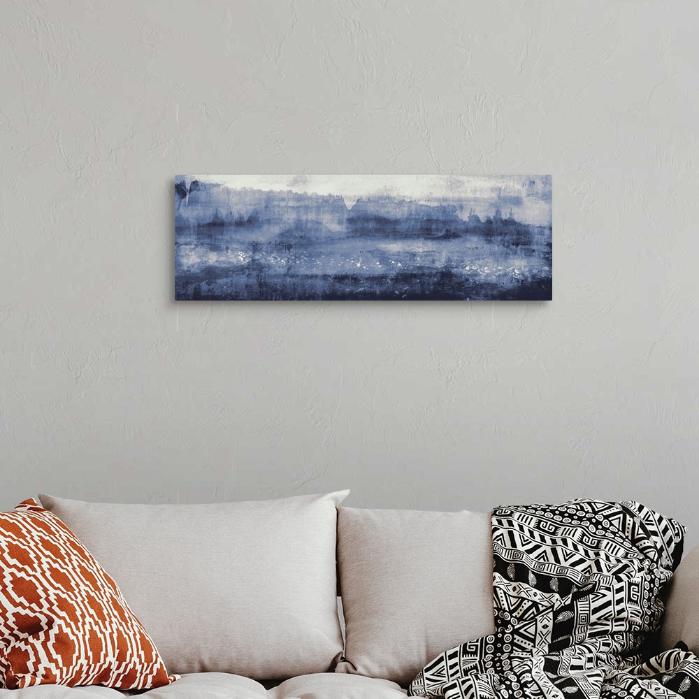 A bohemian room featuring A large contemporary painting representing a landscape in shades of blue.