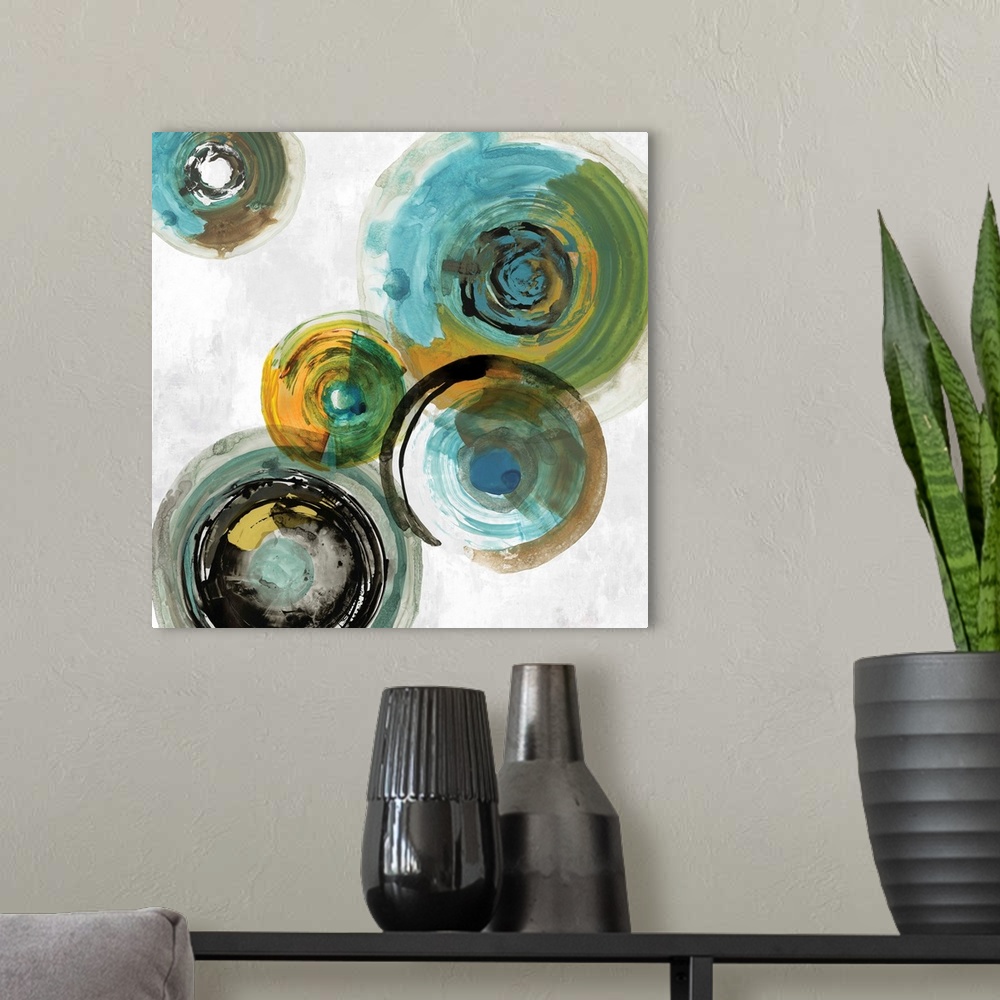 A modern room featuring Square contemporary painting of multi- color circles in tones of blue, green and gold.