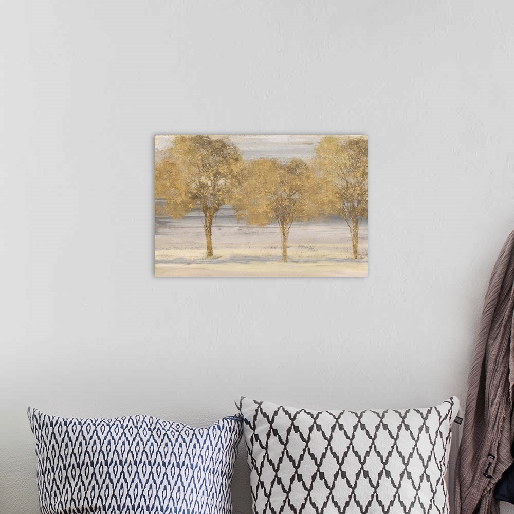 A bohemian room featuring Horizontal painting of a group of trees done in textured gold.