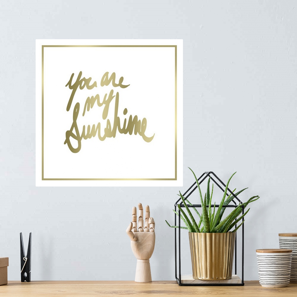 A bohemian room featuring Contemporary home decor typography art of gold lettering against a white background.