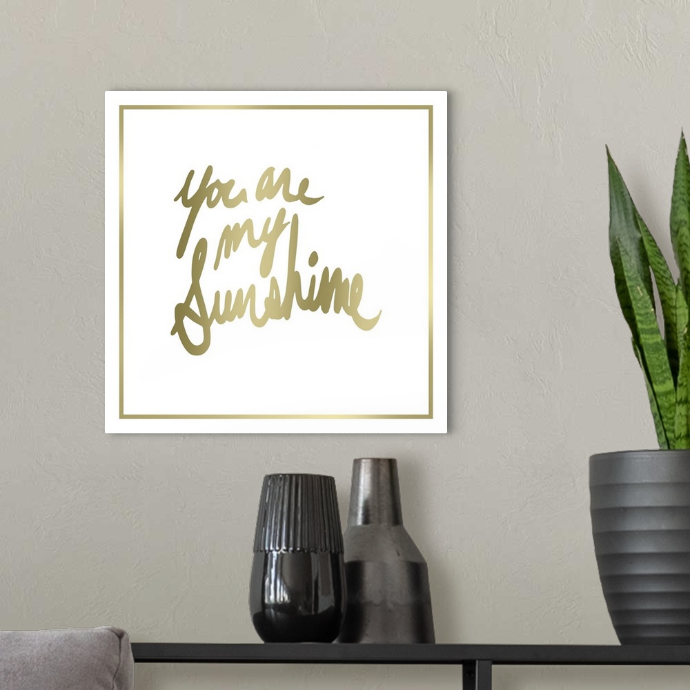 A modern room featuring Contemporary home decor typography art of gold lettering against a white background.