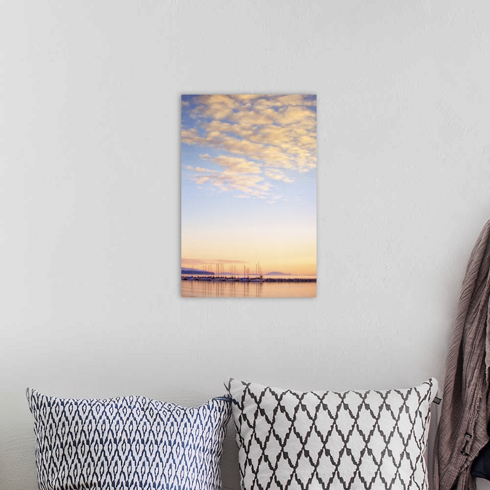 A bohemian room featuring A photo of blue sky with white fluffy clouds over a body of water with sailboats.