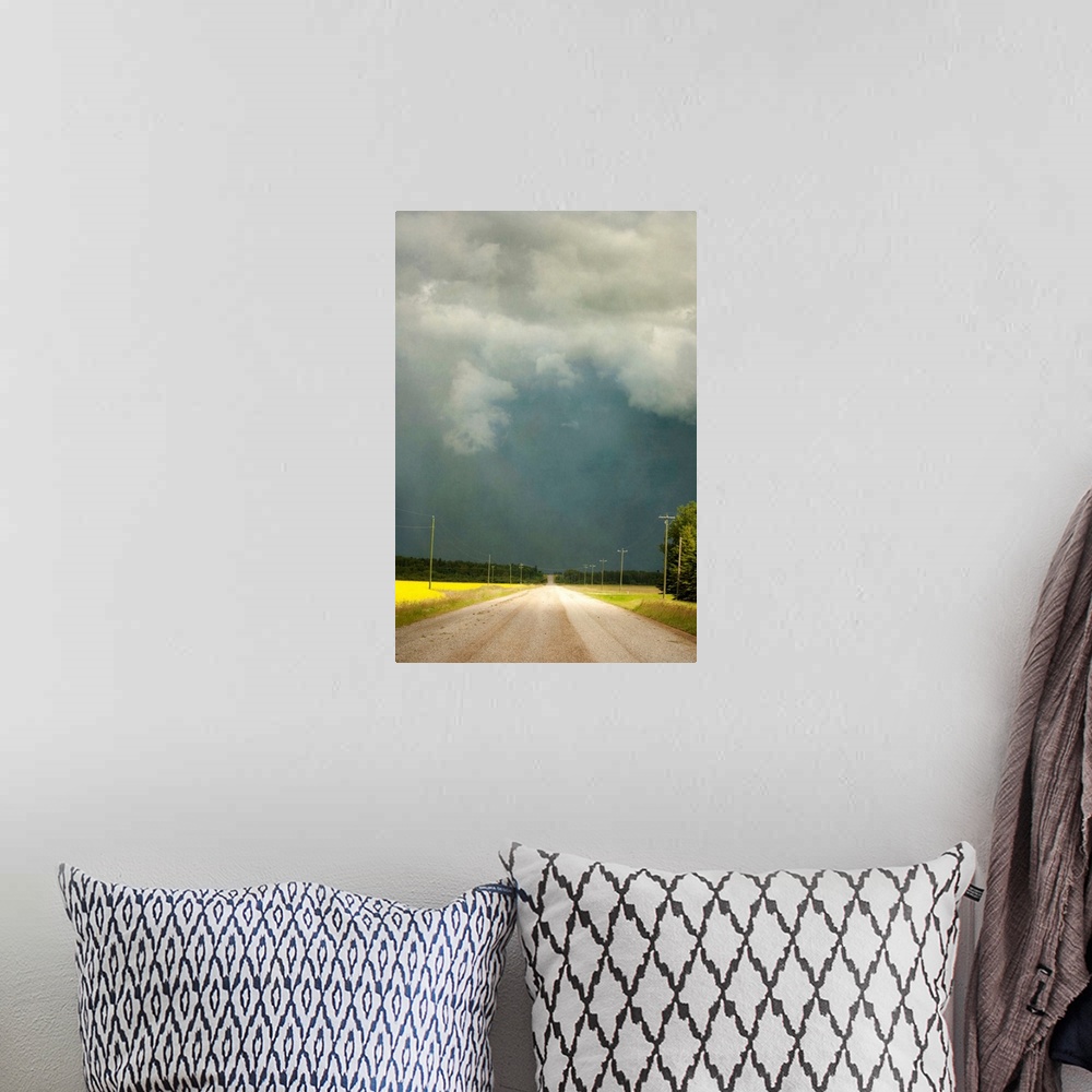 A bohemian room featuring Storm clouds along a lonely stretch of gravel road in the country.