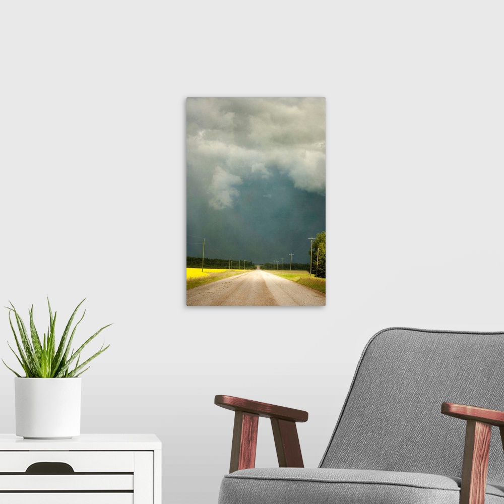 A modern room featuring Storm clouds along a lonely stretch of gravel road in the country.