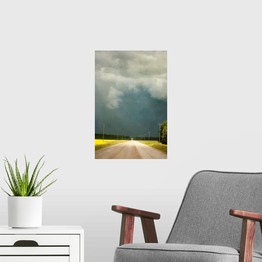 A modern room featuring Storm clouds along a lonely stretch of gravel road in the country.