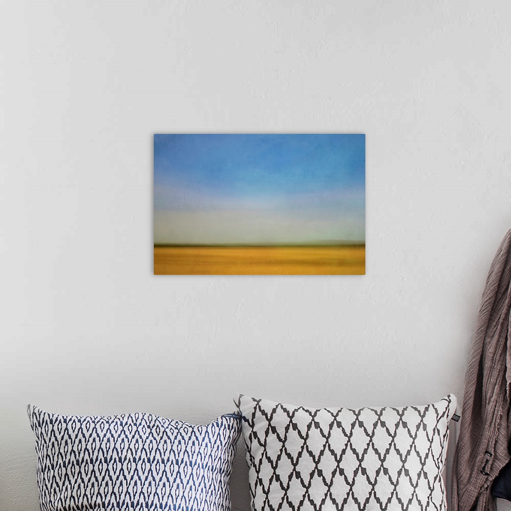 A bohemian room featuring Impressionist landscape of a prairie farm field and blue sky.