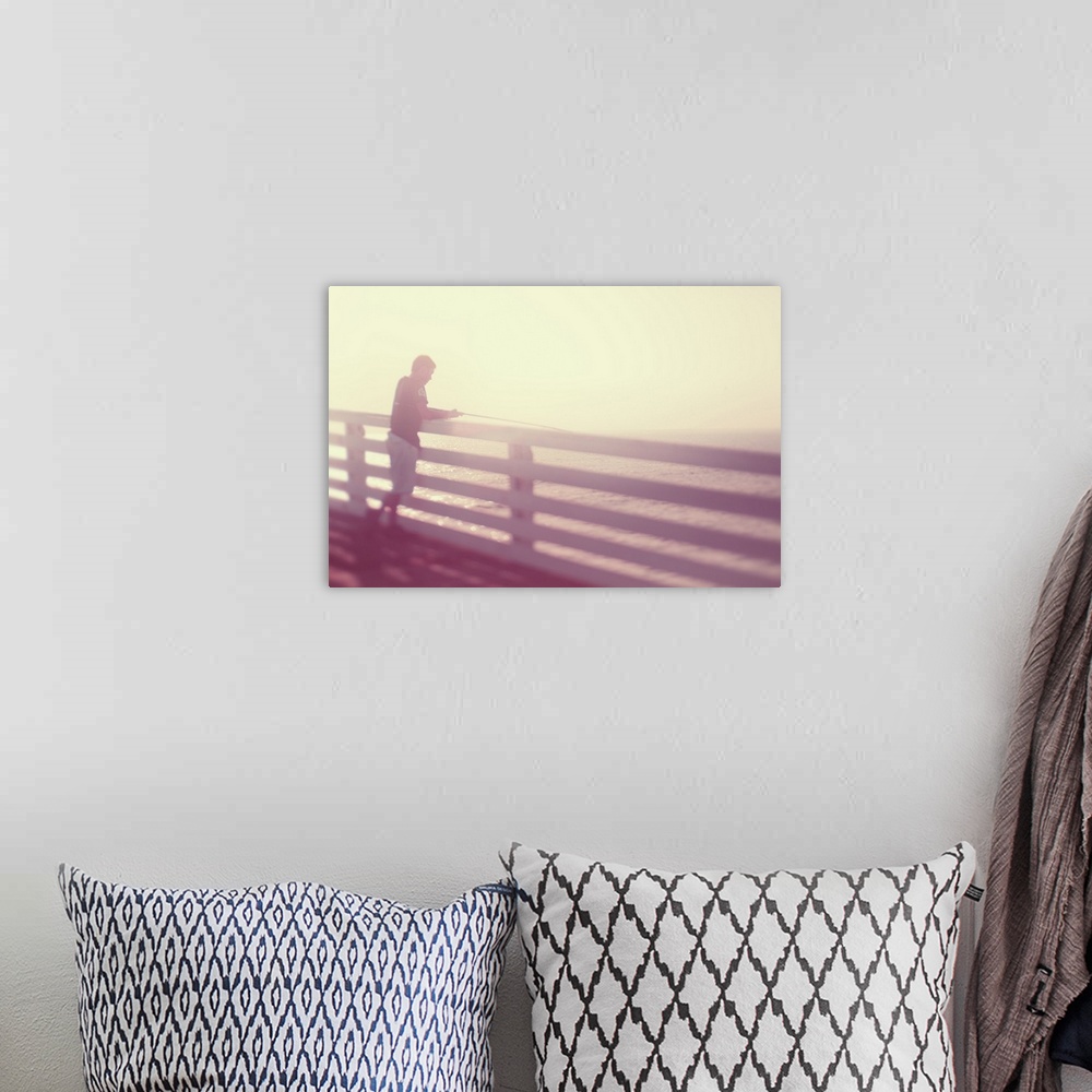 A bohemian room featuring Pictorialist photo of a person fishing from the pier in the sunshine in pink hues.
