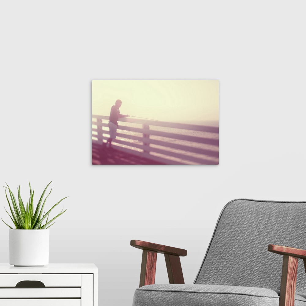 A modern room featuring Pictorialist photo of a person fishing from the pier in the sunshine in pink hues.