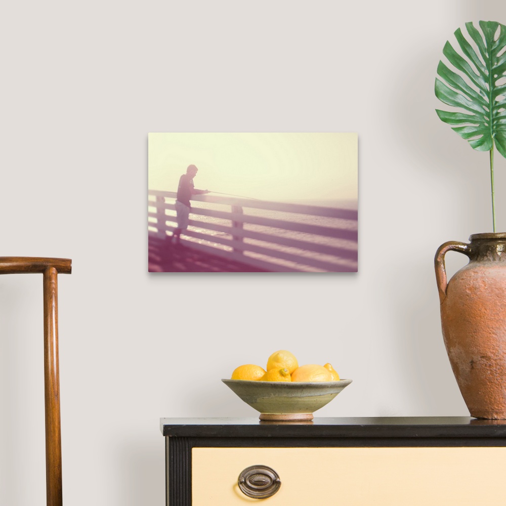 A traditional room featuring Pictorialist photo of a person fishing from the pier in the sunshine in pink hues.