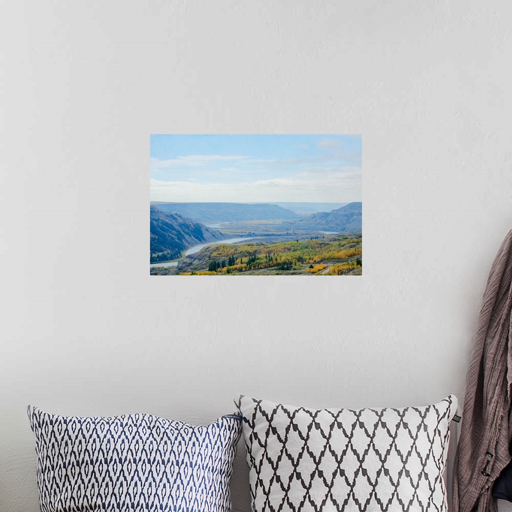 A bohemian room featuring A photo of a scenic view of a river valley during fall.