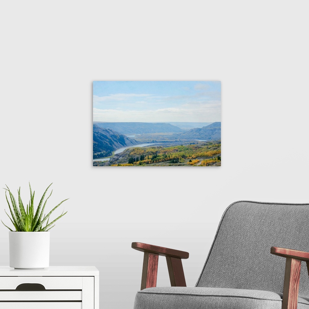 A modern room featuring A photo of a scenic view of a river valley during fall.