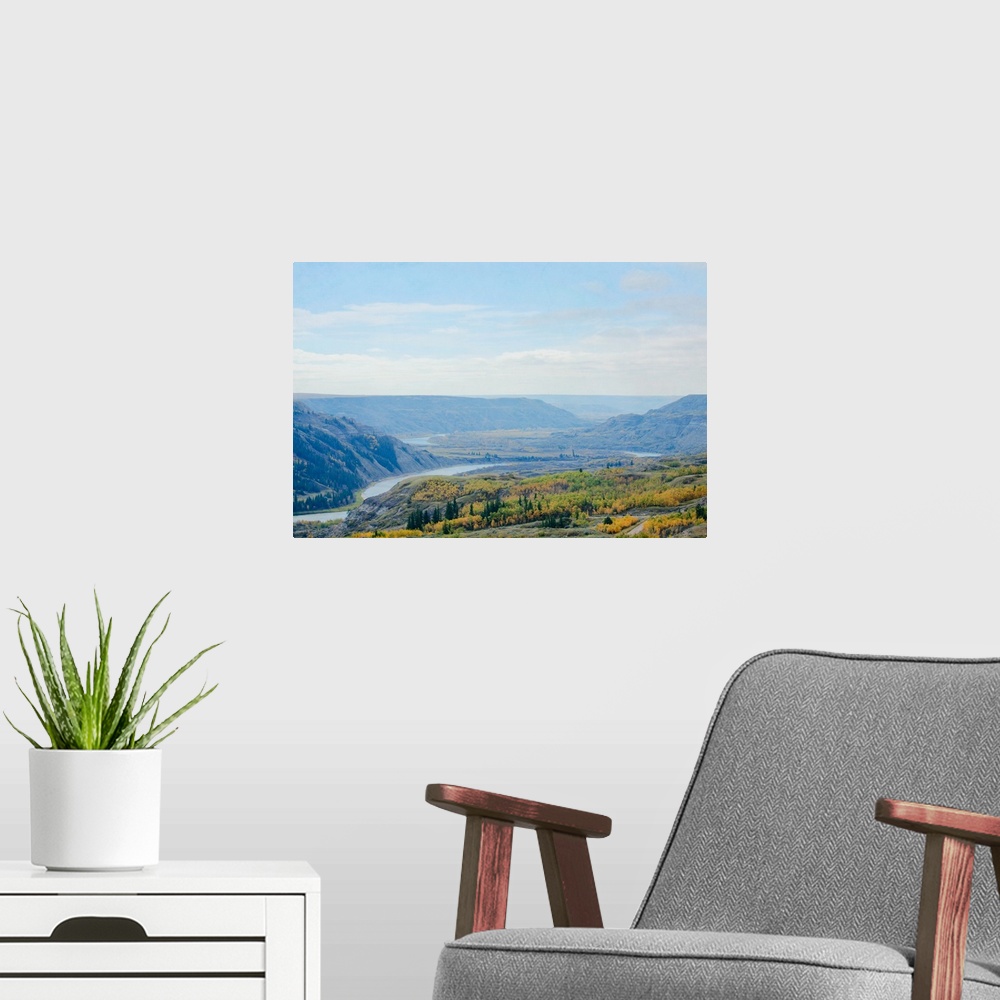 A modern room featuring A photo of a scenic view of a river valley during fall.