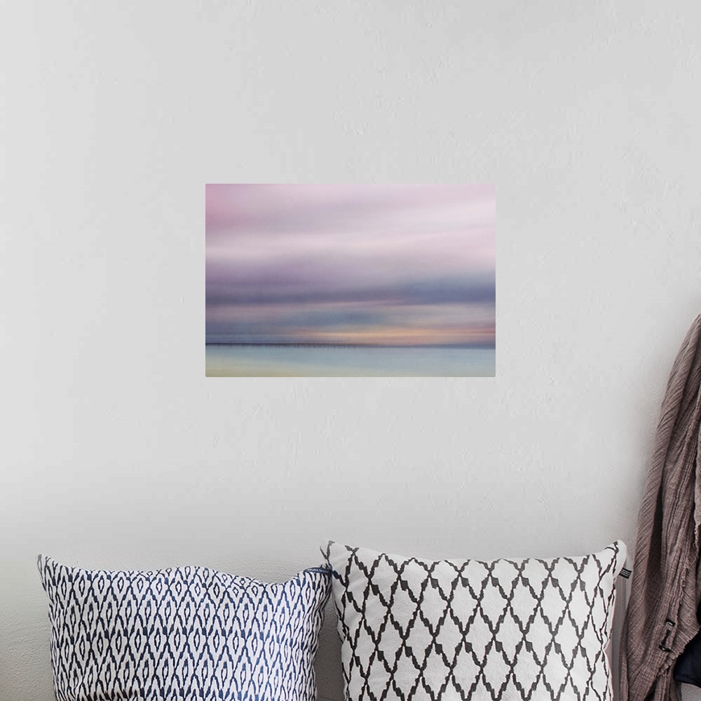 A bohemian room featuring Photograph of a seascape under a blanket of smooth pale purple clouds.