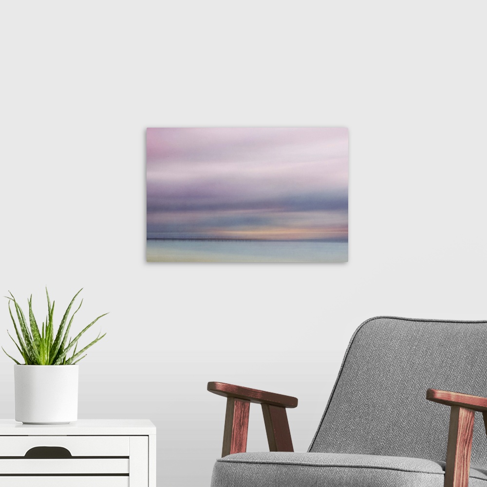 A modern room featuring Photograph of a seascape under a blanket of smooth pale purple clouds.