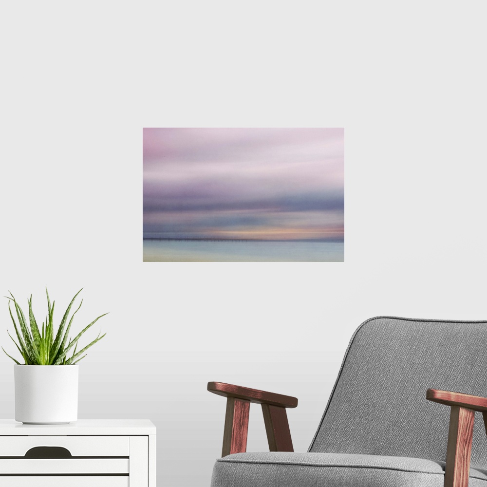 A modern room featuring Photograph of a seascape under a blanket of smooth pale purple clouds.