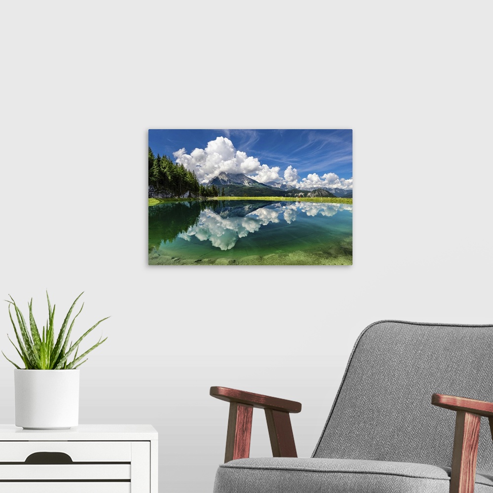A modern room featuring A clear lake in Berchtesgaden, Germany, reflecting the clouds and mountains.