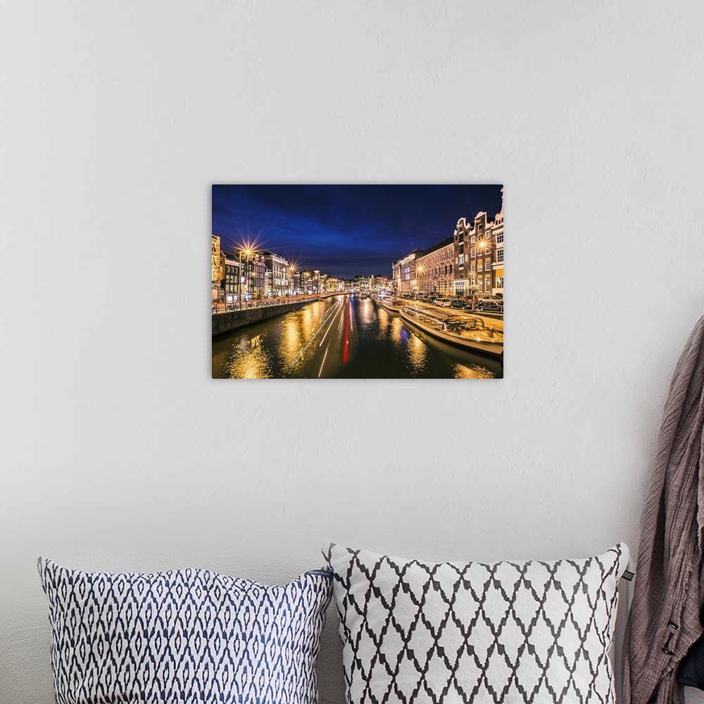 A bohemian room featuring Boats in the canal at night, reflecting street lights, Amsterdam.