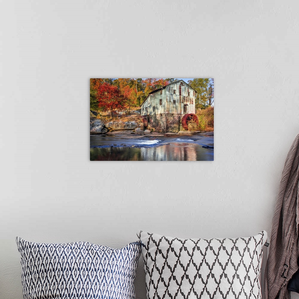 A bohemian room featuring Photograph of a watermill in forest with autumn foliage.