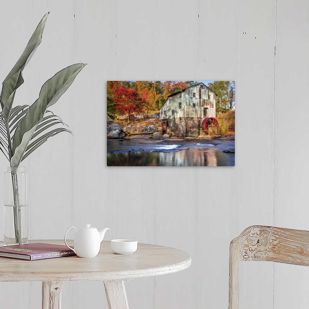 A farmhouse room featuring Photograph of a watermill in forest with autumn foliage.