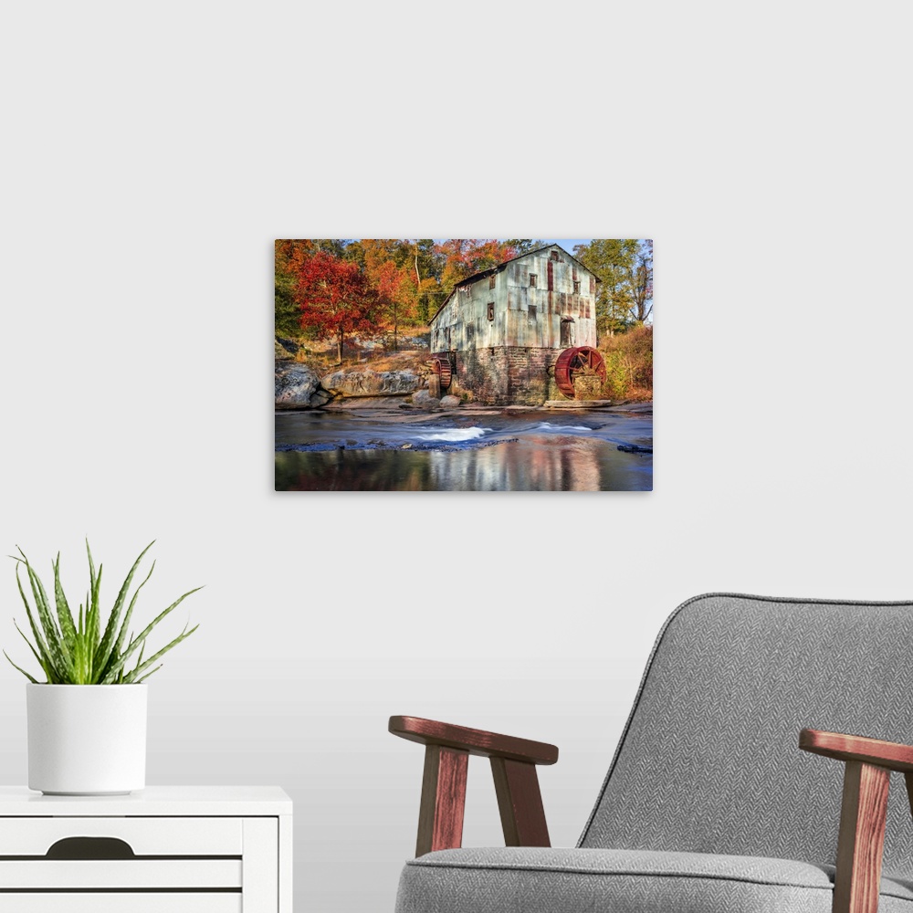 A modern room featuring Photograph of a watermill in forest with autumn foliage.