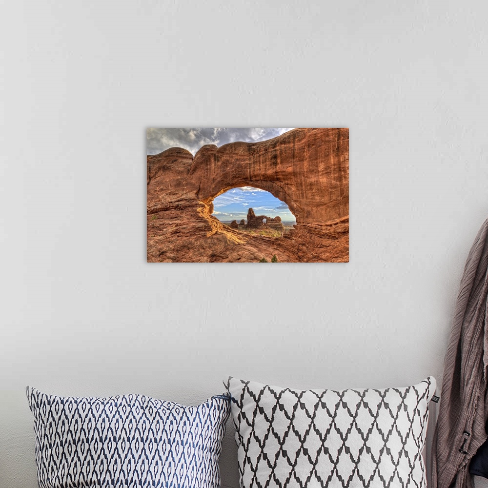 A bohemian room featuring Photograph of a large rock formation seen through a rock arch.