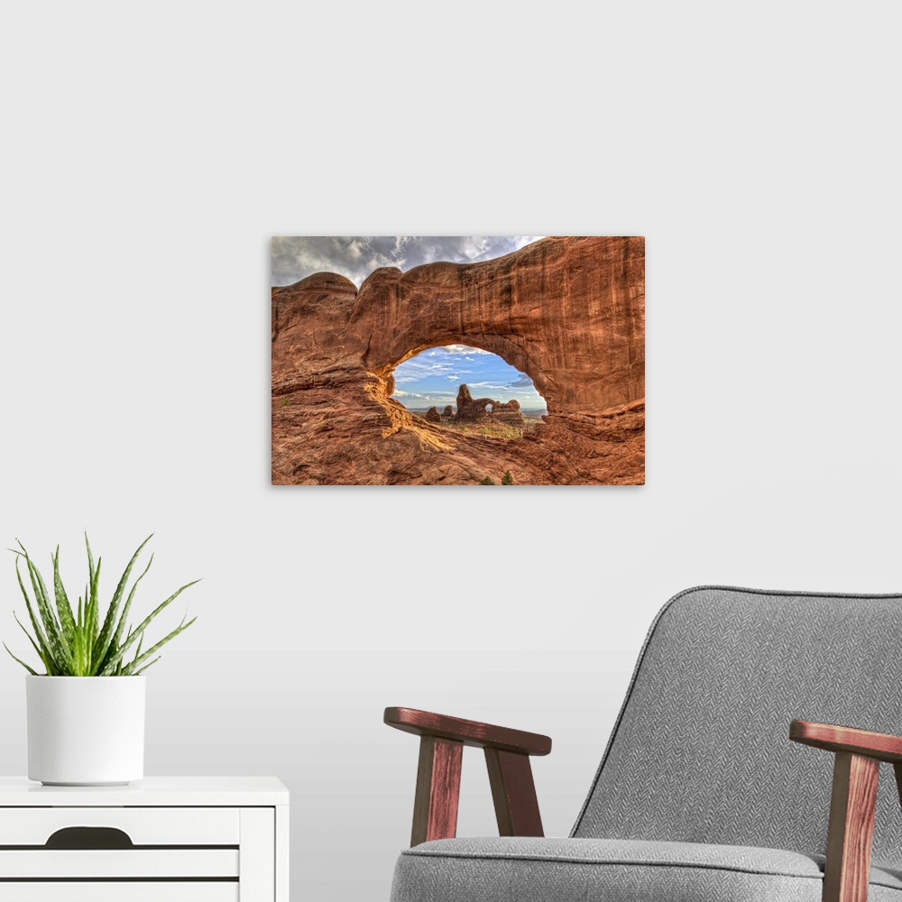 A modern room featuring Photograph of a large rock formation seen through a rock arch.