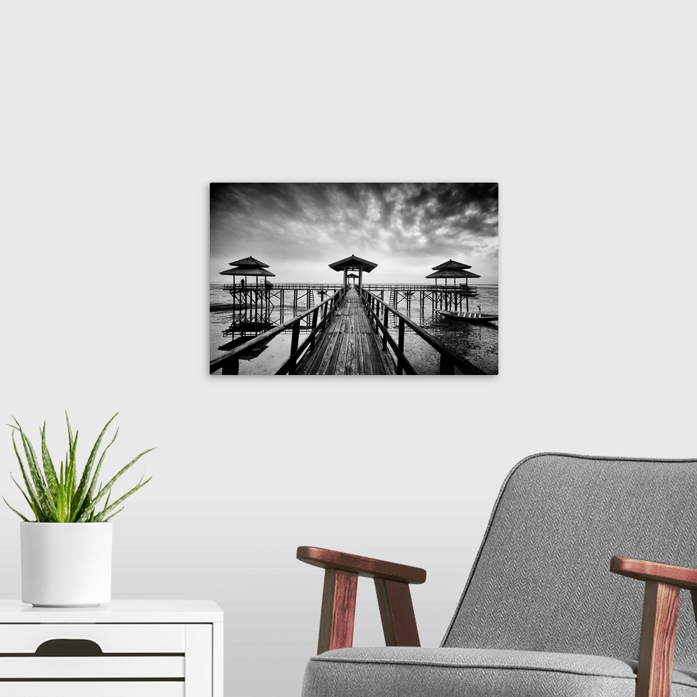 A modern room featuring Black and white photo of a wooden pier in Kenji Beach, East Java, Indonesia.