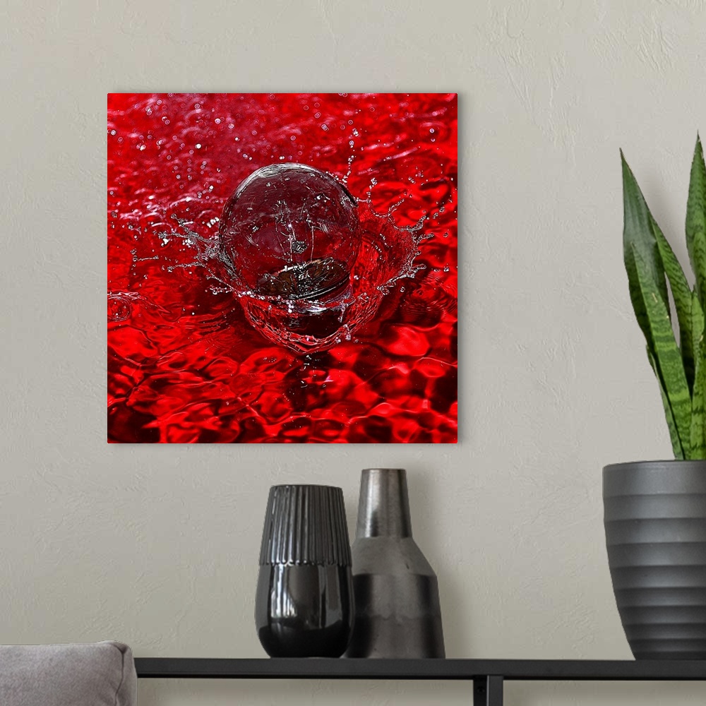 A modern room featuring Macro photograph of a water drop splashing into water reflecting bright red.