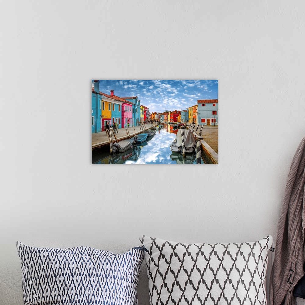 A bohemian room featuring Colorful buildings along the canal reflecting the clouds above, Italy.