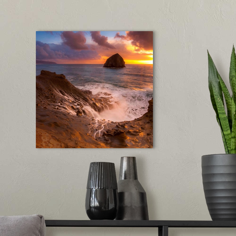 A modern room featuring Haystack Rock in the ocean at sunset, seen from the shore at Cape Kiwanda, Oregon.