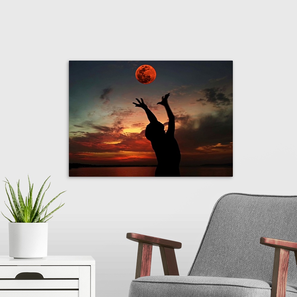 A modern room featuring Silhouette of a person with their arms outstretched towards the red moon in the sky.