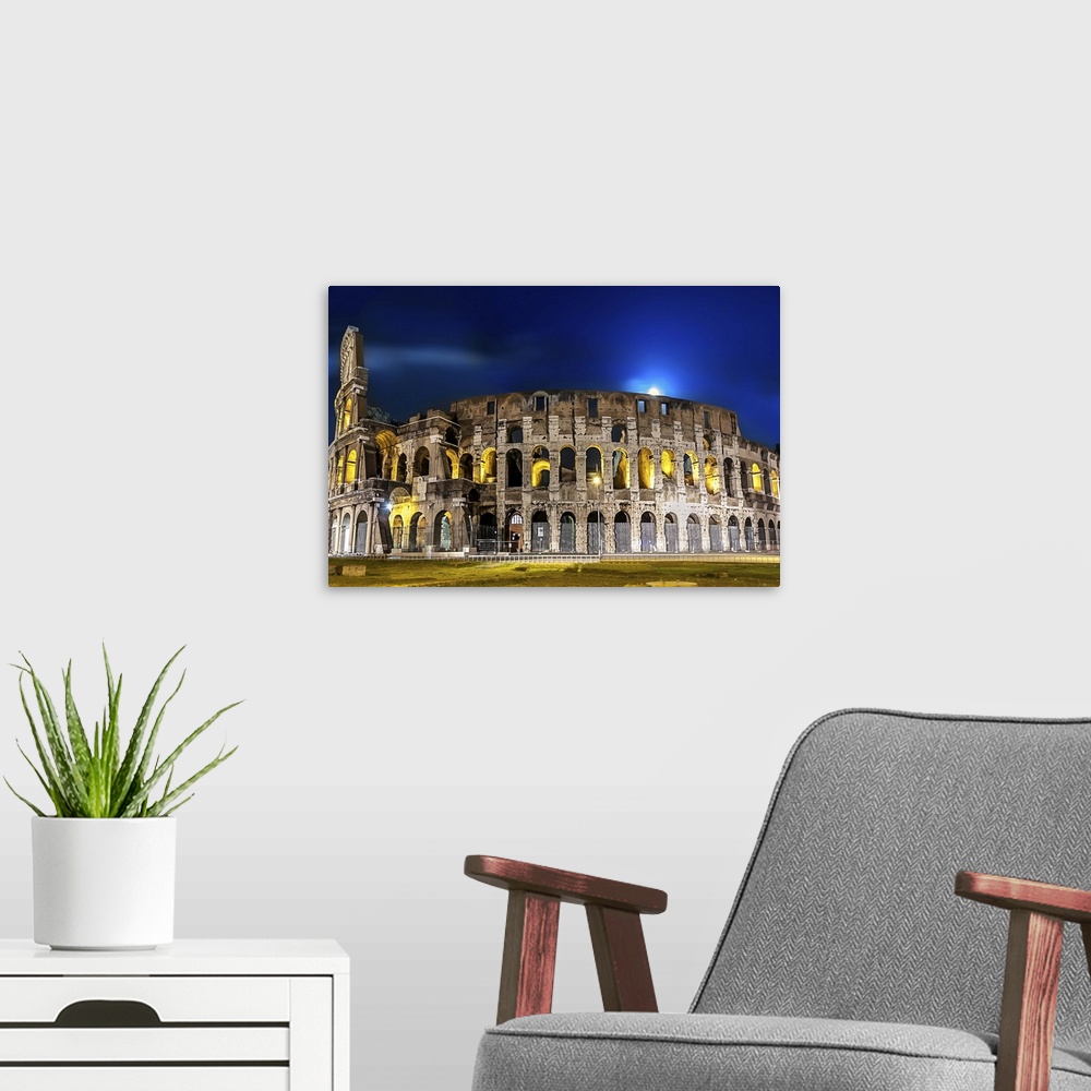 A modern room featuring The Colosseum in Rome lit up at night.