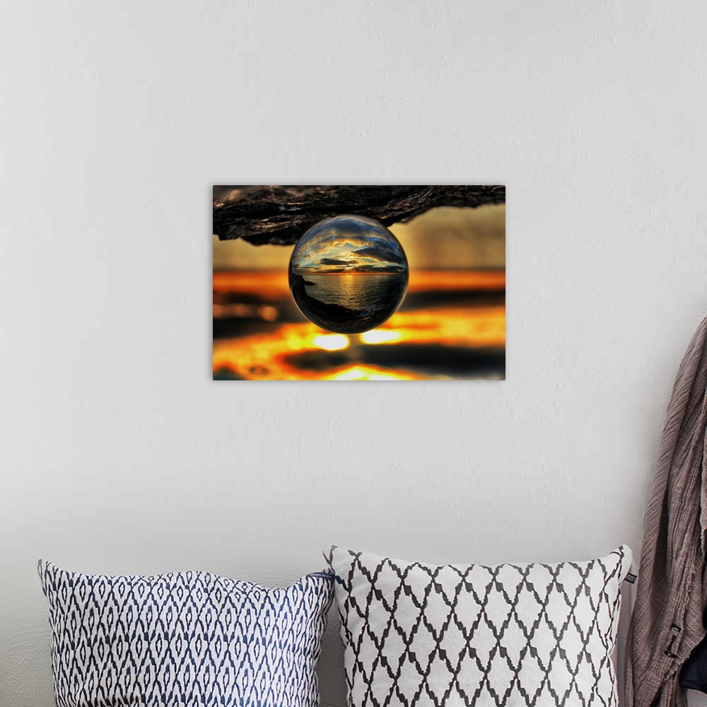 A bohemian room featuring A sunset seascape reflected right-side-up in an upsidedown glass ball.