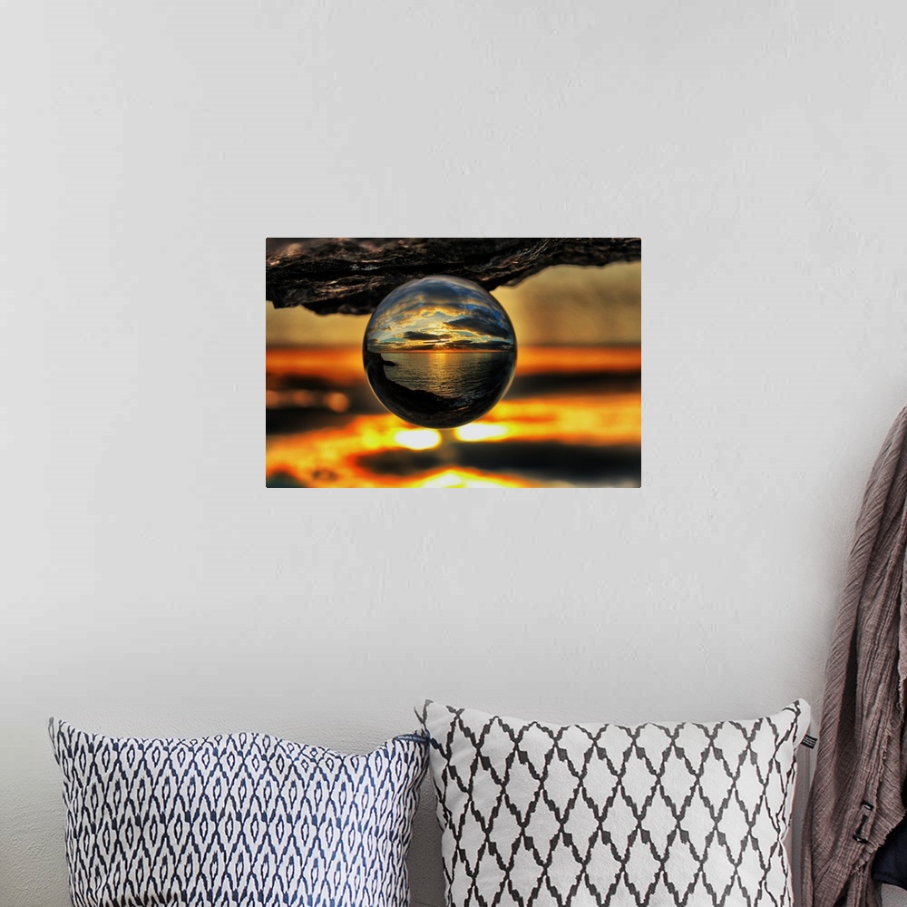 A bohemian room featuring A sunset seascape reflected right-side-up in an upsidedown glass ball.