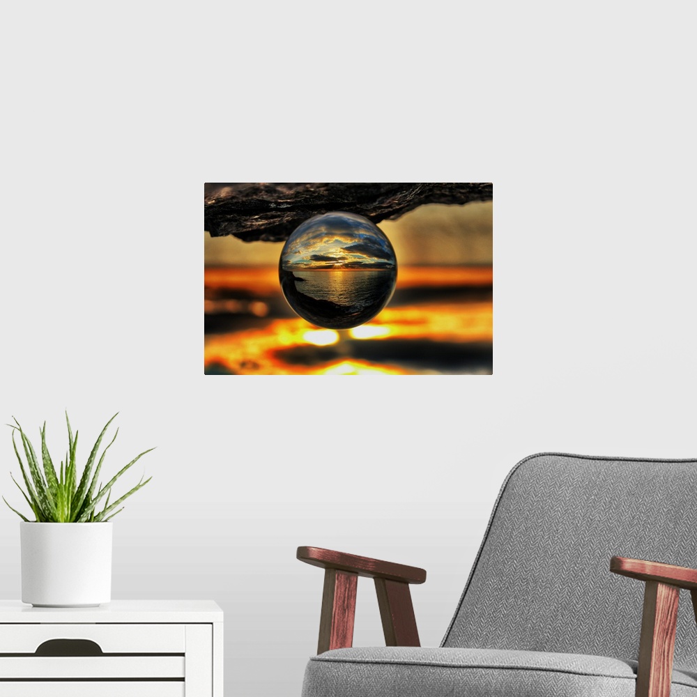 A modern room featuring A sunset seascape reflected right-side-up in an upsidedown glass ball.