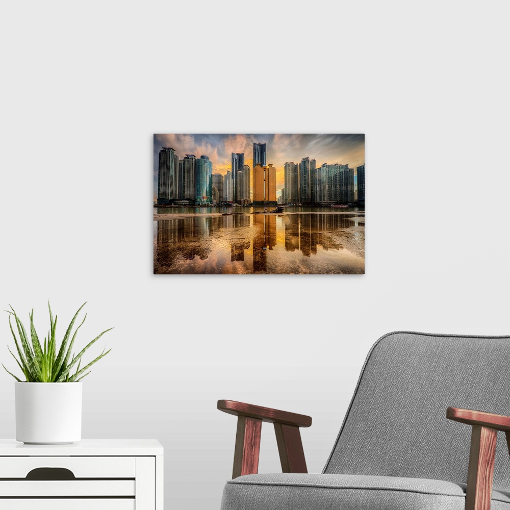 A modern room featuring Dramatic photograph of a city skyline with immense skyscraper reflected in a puddle in the foregr...