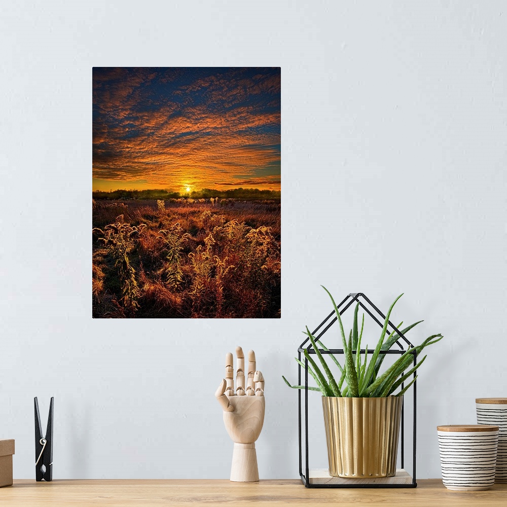 A bohemian room featuring Golden sunset and brilliant clouds over a field of farmland.