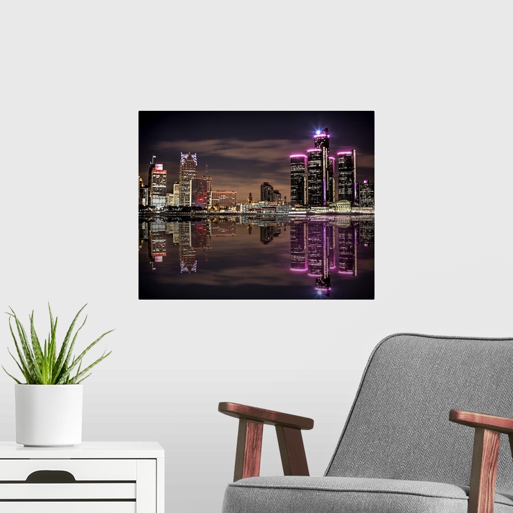 A modern room featuring The Detroit skyline as seen from Windsor at night.