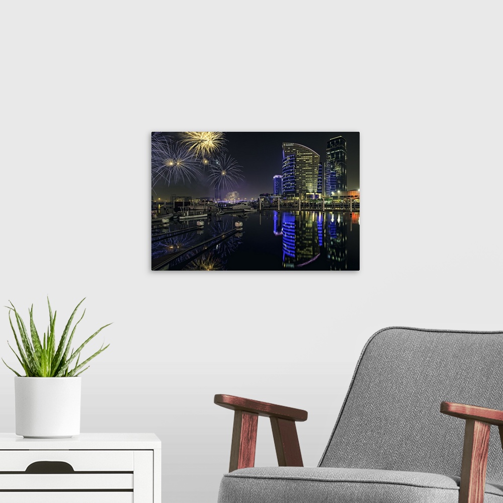 A modern room featuring Dubai Festival City Fireworks over the city skyline at night.