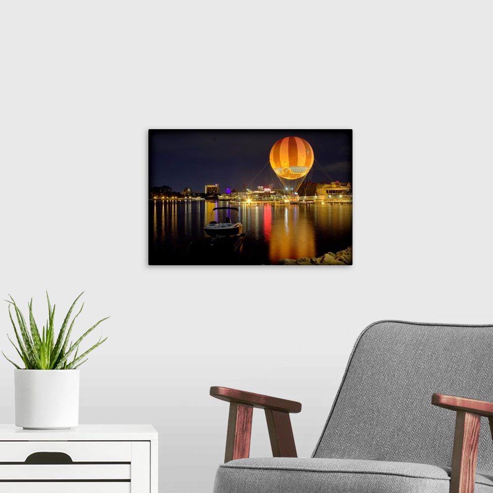 A modern room featuring A hot air balloon glowing against the night sky over a lake.