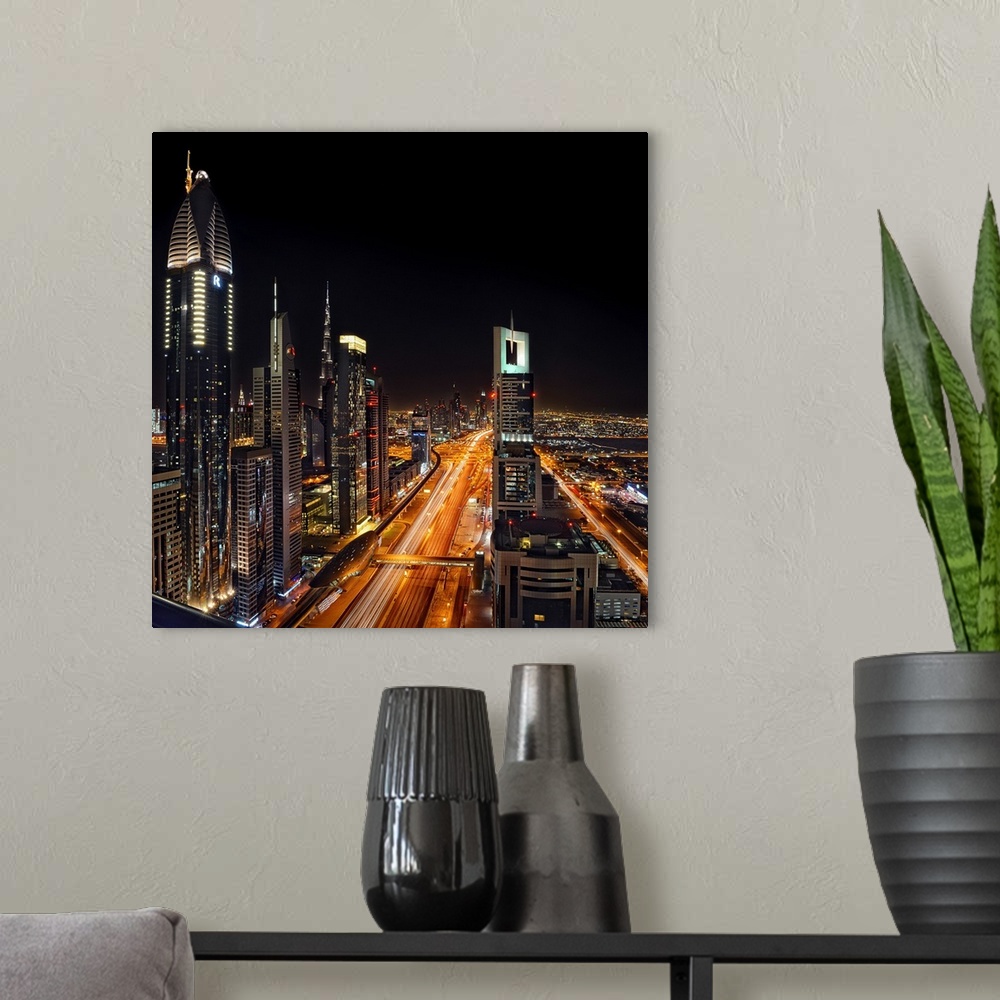 A modern room featuring Aerial photograph of Dubai at night with highways covered in light trails from moving vehicles.