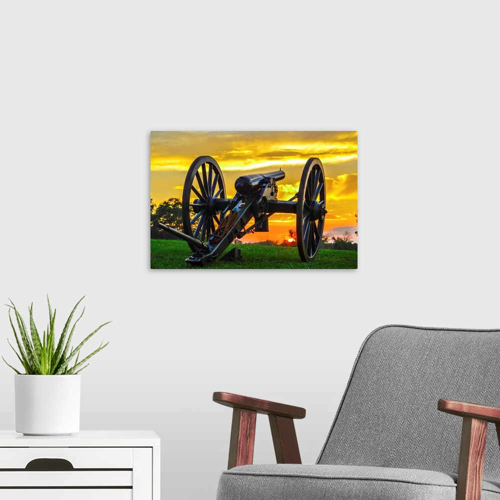 A modern room featuring A historical cannon on an old battlefield at sunset.