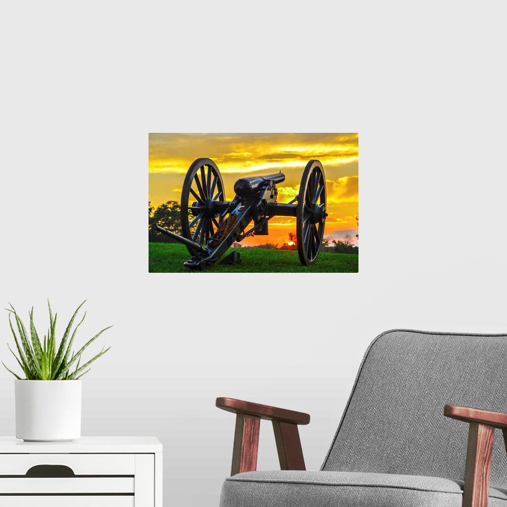 A modern room featuring A historical cannon on an old battlefield at sunset.