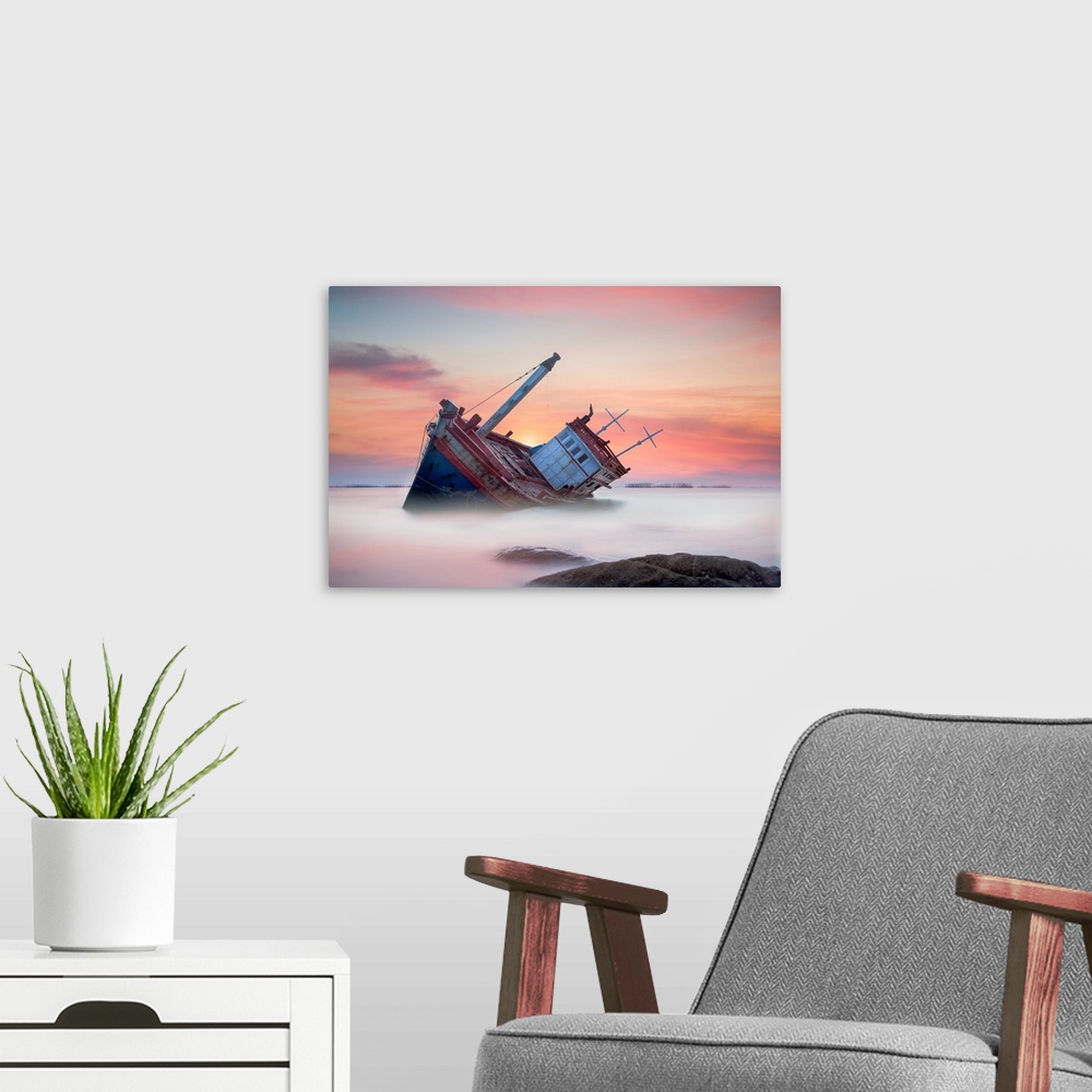 A modern room featuring Fishing boat beached in the shallow water, seen at sunset.