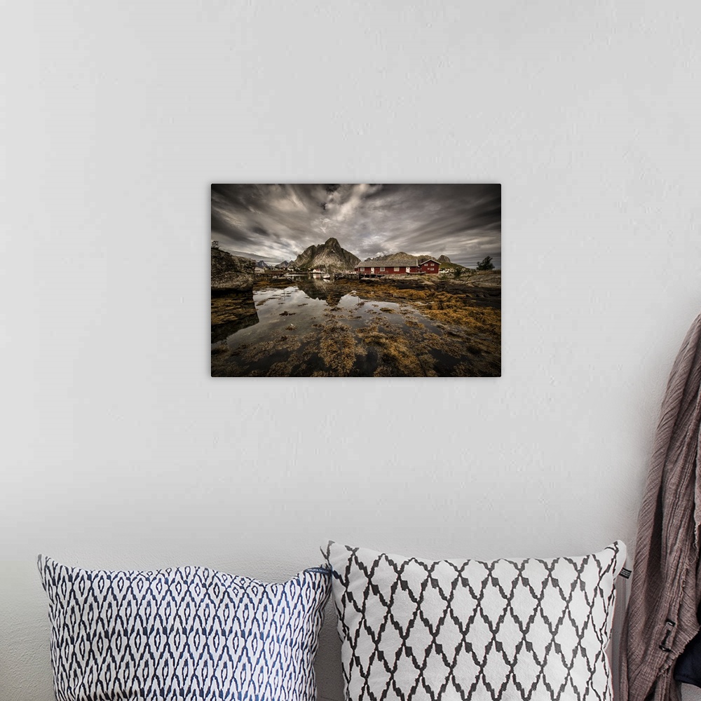 A bohemian room featuring Dynamic photograph of a fishing village under cloudy skies.