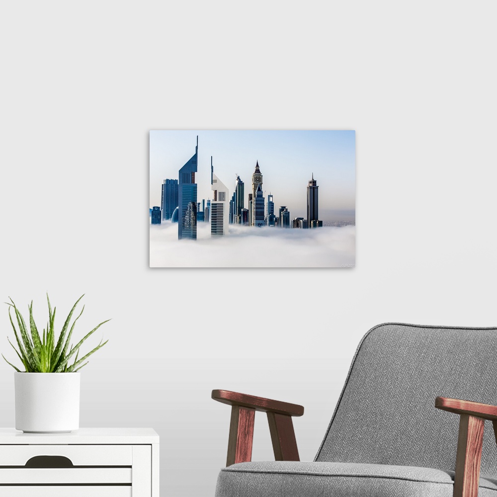 A modern room featuring Jumeirah Emirates Towers stand tall in the fog with the Arabian Gulf in the background.