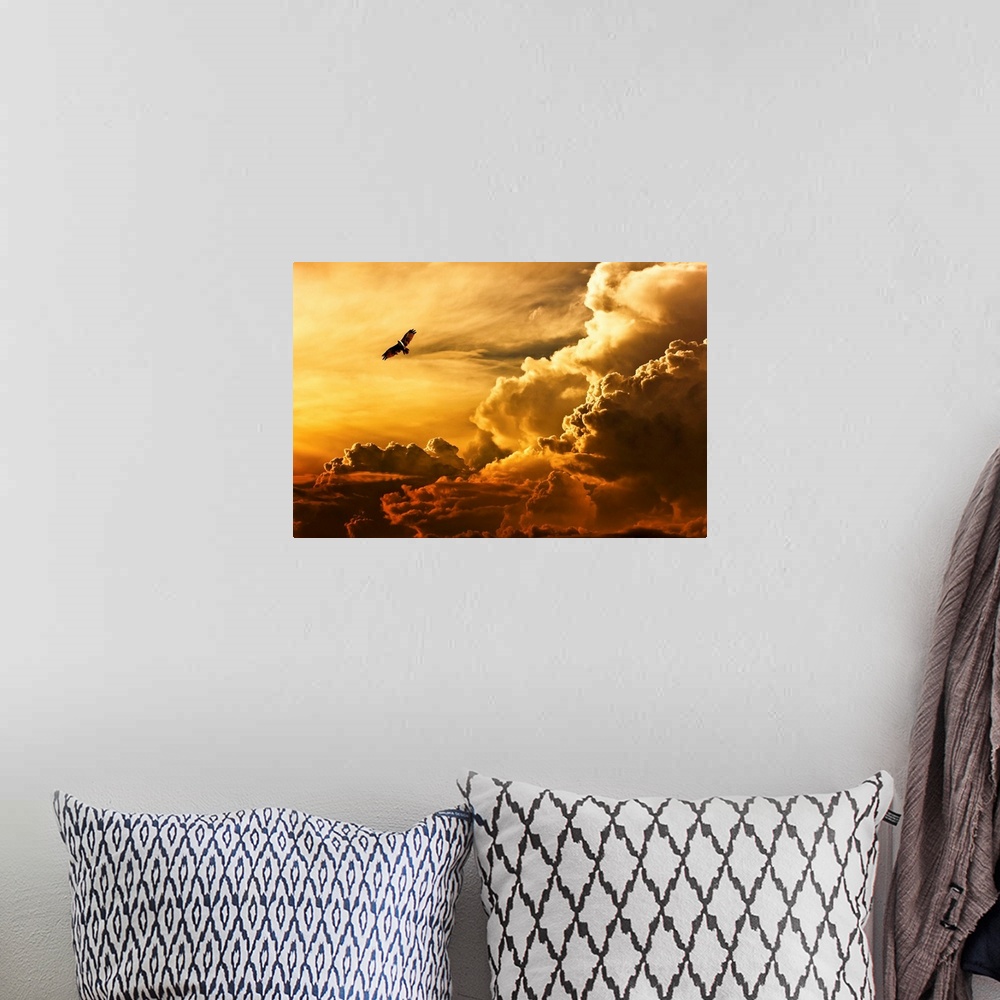 A bohemian room featuring An eagle flying in the sky over large clouds at sunset.
