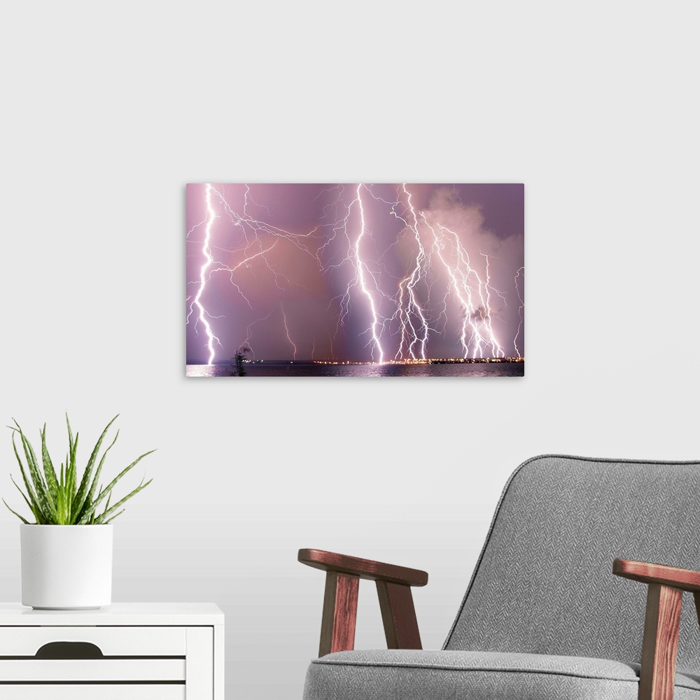 A modern room featuring Multiple lightning strikes during a storm over a city.